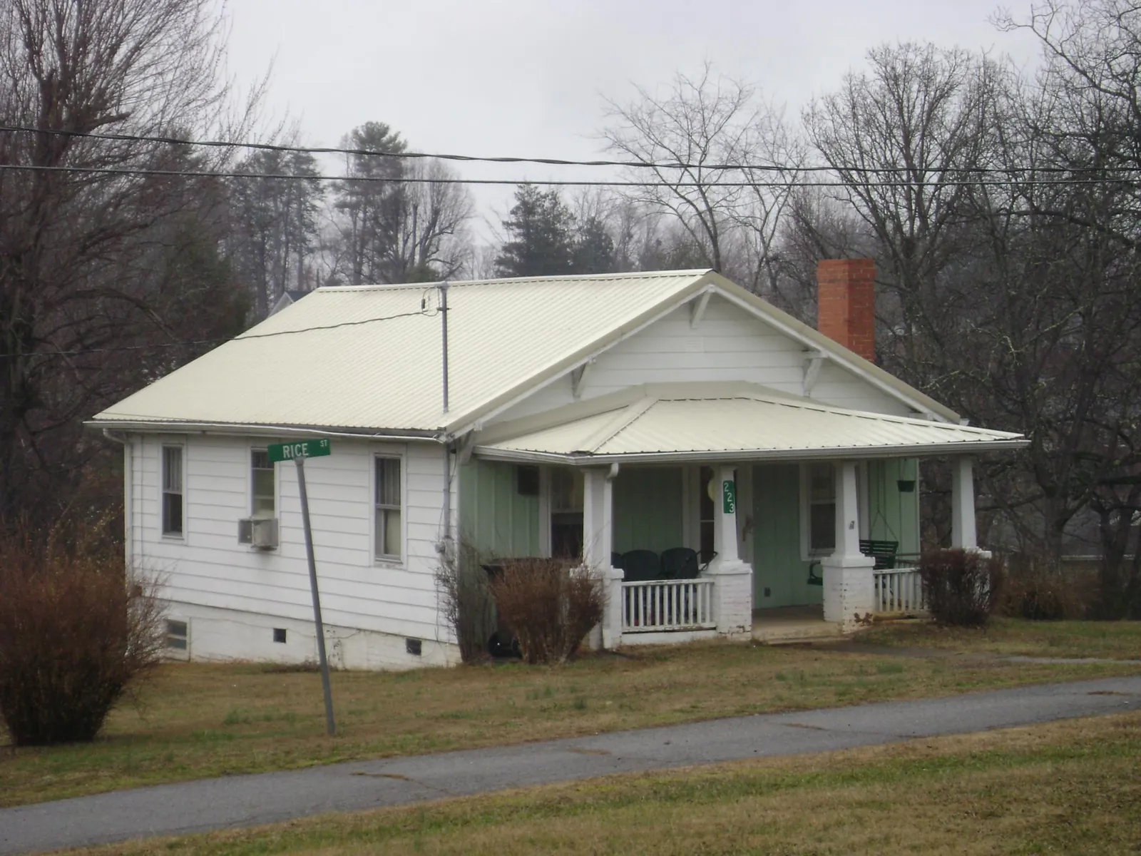 White metal roof on a craftsman bungalow at a street corner in Pine Hill
