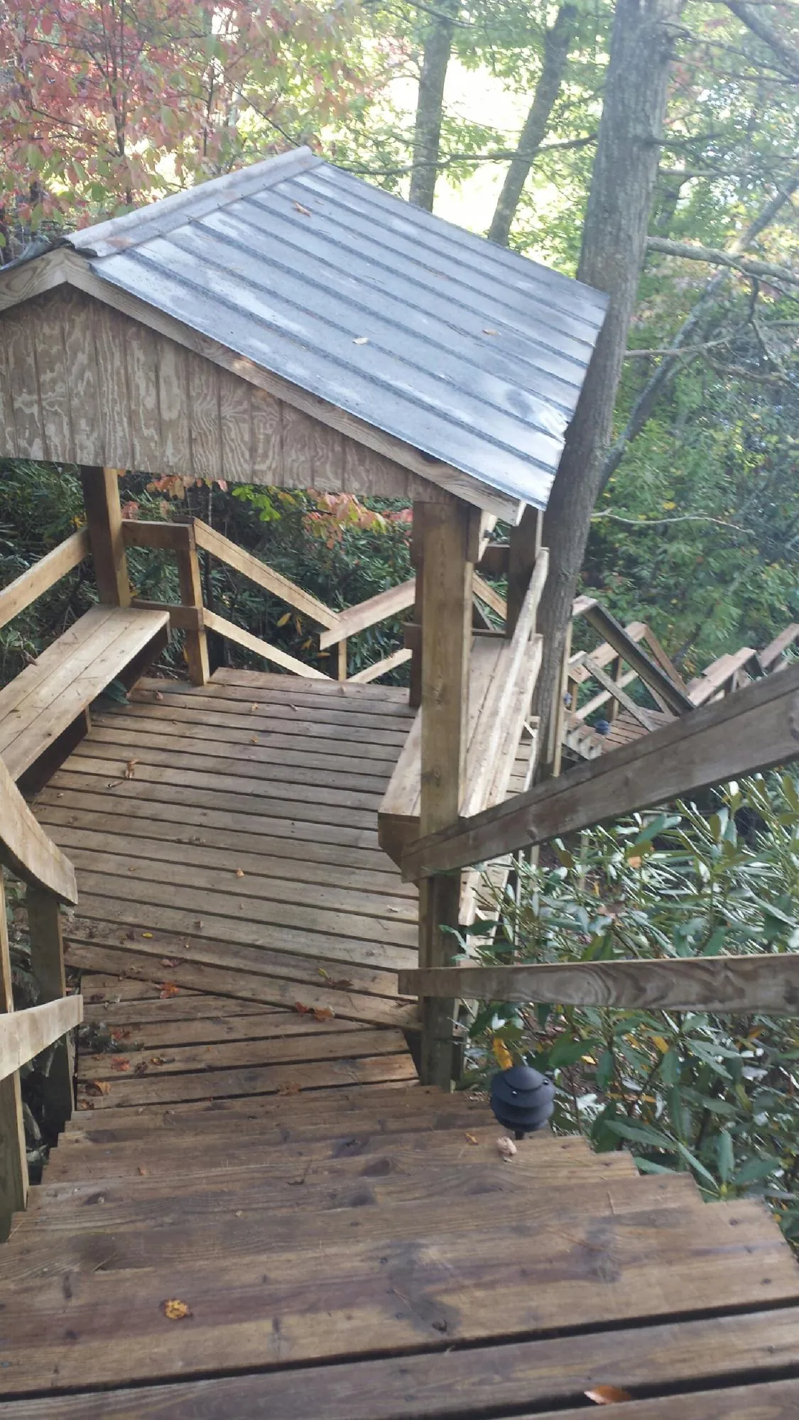 Metal roofed shelter over wooden steps on a wooded walkway — Skylight Repair & Installation work by our crew in Pine Hill